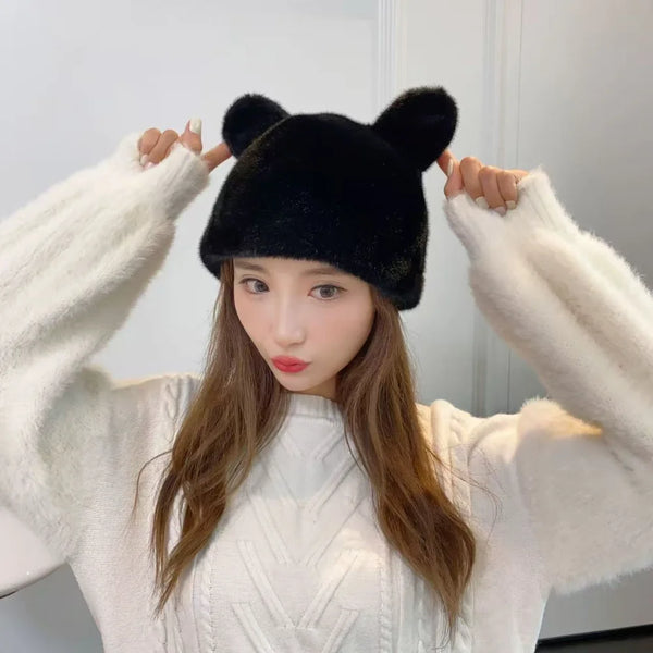 Woman wearing a black fluffy bear ear hat with a white sweater