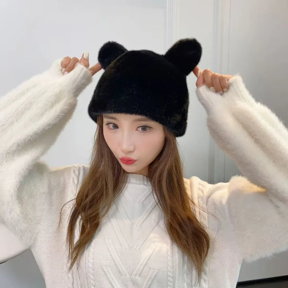 Woman wearing a black fluffy bear ear hat with a white sweater