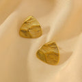 Gold brushed triangle stud earrings on cream satin