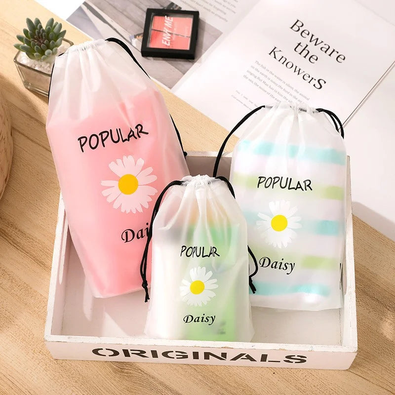 Daisy drawstring storage bags filled with clothes and toiletries in a white tray