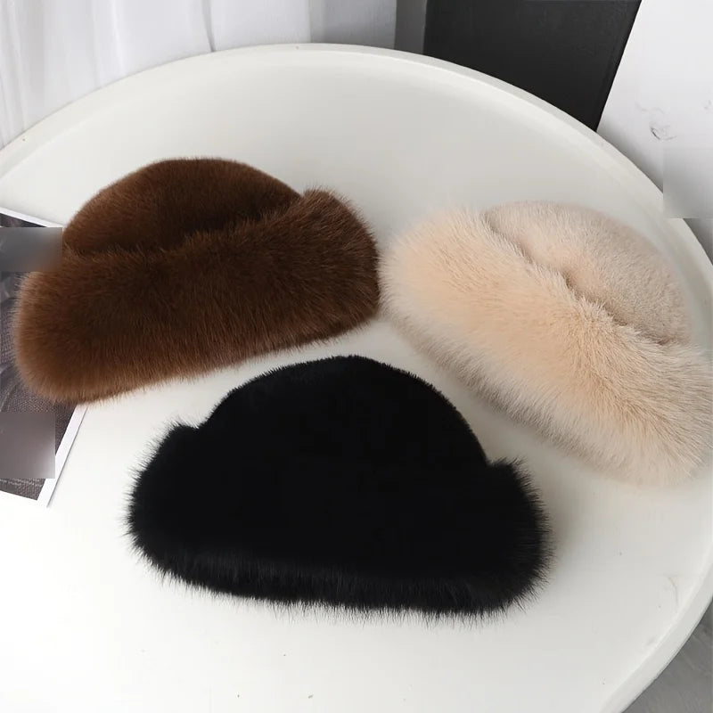 Brown, beige and black faux fur winter hats on a white table