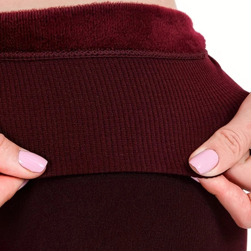 Close-up of the high ribbed waistband and plush fleece lining on wine leggings