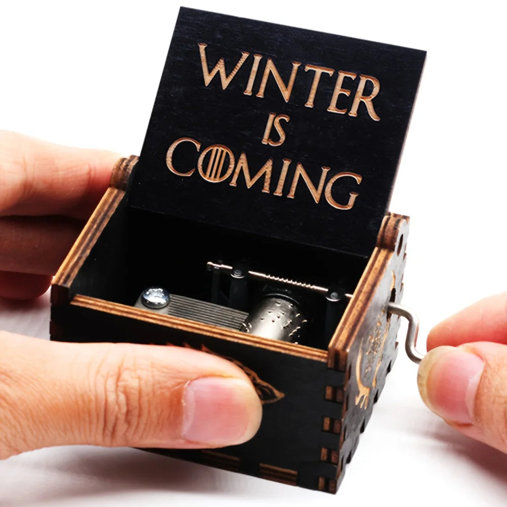 Hands turning the crank of the Winter Is Coming wooden music box