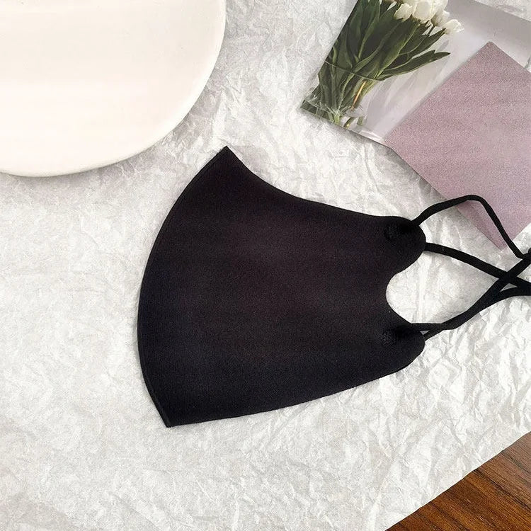 Black 3D shaped ice silk face mask laid flat