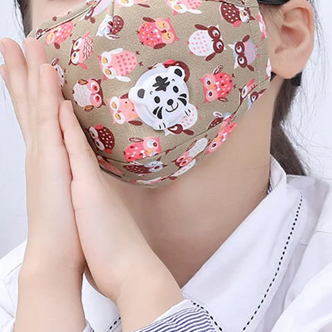 Child wearing the beige owl print kids face mask with tiger valve