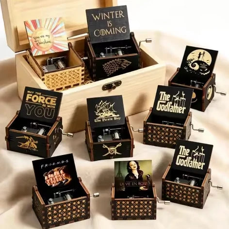 Collection of engraved wooden hand-crank music boxes in a wooden gift box