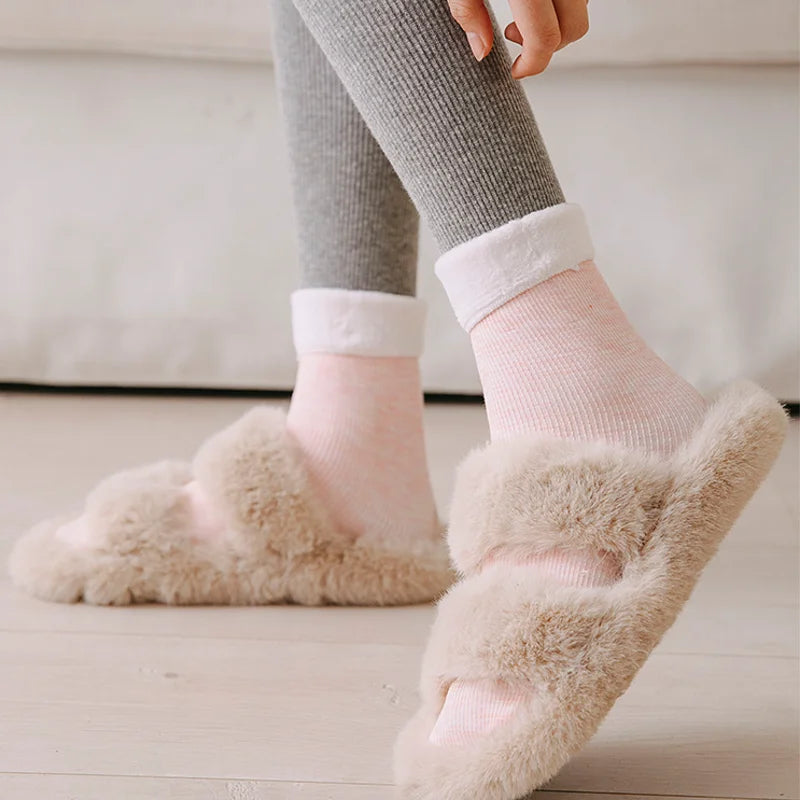 Pink premium fleece-lined socks worn with fluffy slippers and a folded plush cuff