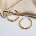 Gold textured cluster C-hoop earrings on champagne satin