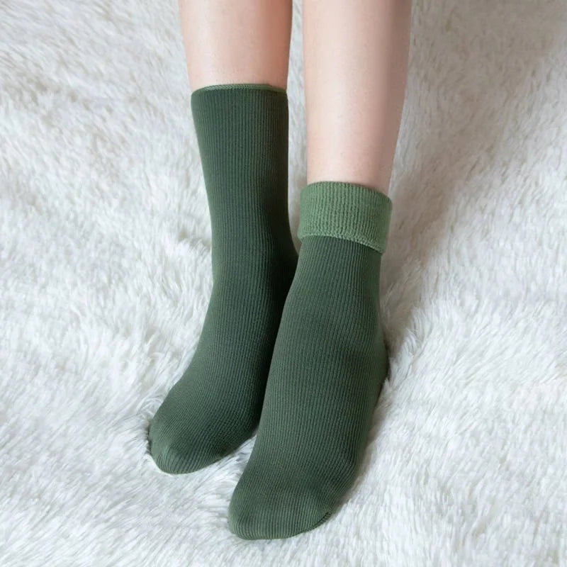 Person wearing olive green thermal fleece-lined winter socks with the cuff folded down to show the fleece lining