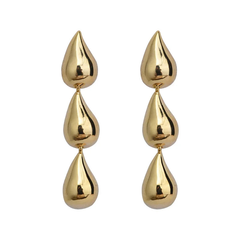 Gold triple teardrop drop earrings on a white background