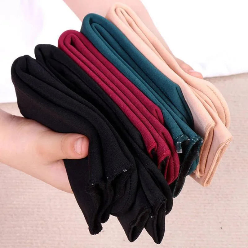 Hand holding a stack of velvet thermal socks in black, maroon, green and skin colour