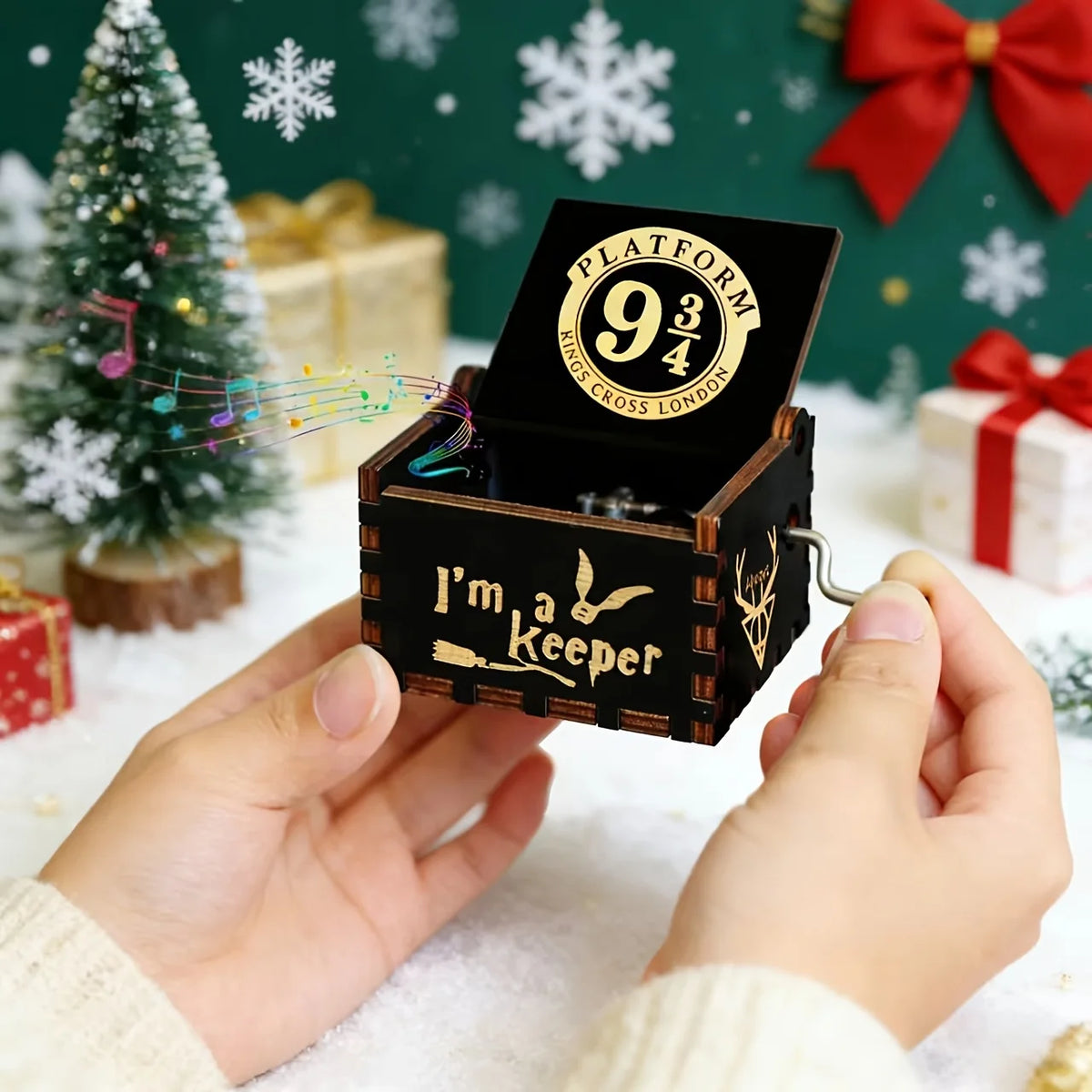 Hands turning the crank of the Platform 9 3/4 wooden music box
